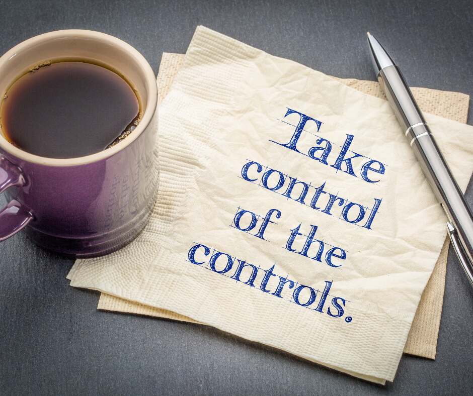 A cup of coffee sitting on a paper note saying Take control of the controls